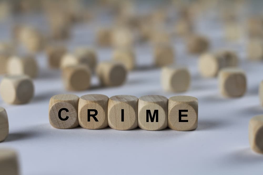 Wooden cubes arranged to spell the word 'crime,' representing the concept of crime in a symbolic manner.