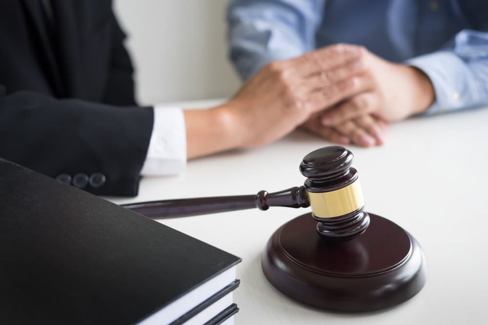 Judge gavel with lawyers advice legal at law firm in background